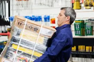 man carrying big stack of items